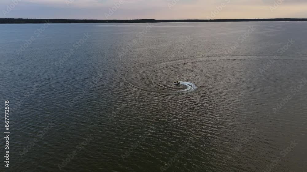 Jezioro, mężczyznę pływa na skuterze wodnym robi piruety, kręci kółka, wodny Sport, z góry, zdjęcia z lotu ptaka, widok z drona. Jezioro, mężczyznę pływa na skuterze wodnym robi piruety, kręci kółka, wodny Sport, z góry, zdjęcia z lotu ptaka, widok z drona.