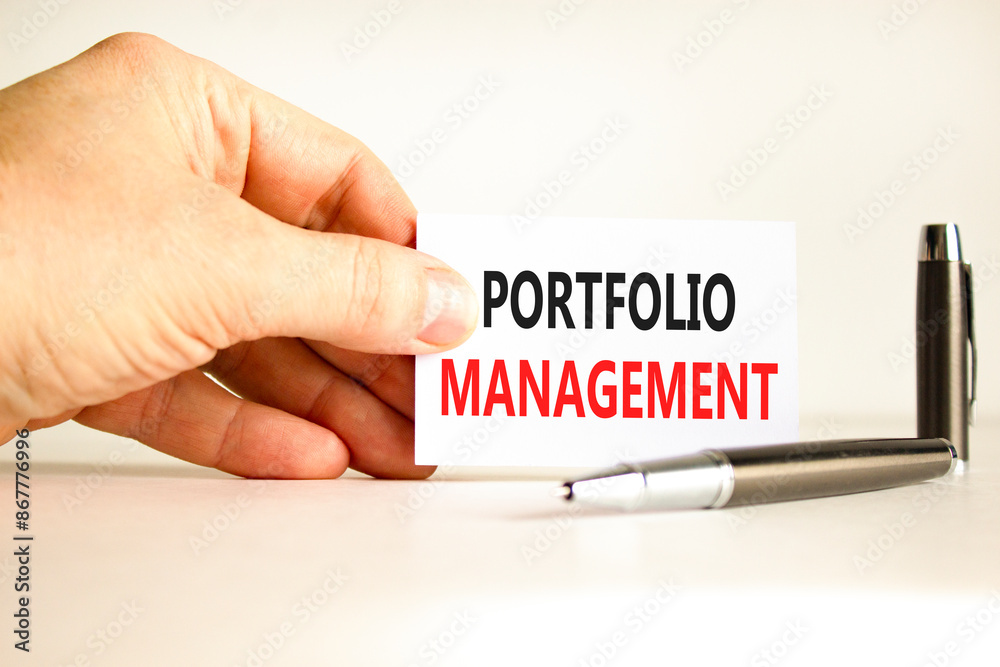 Portfolio management symbol. Concept words Portfolio management on beautiful white paper. Beautiful white background. Businessman hand. Business Portfolio management concept. Copy space. Portfolio management symbol. Concept words Portfolio management on beautiful white paper. Beautiful white background. Businessman hand. Business Portfolio management concept. Copy space.