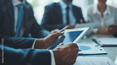 Business People Working on Digital Tablet During Meeting in Boardroom
