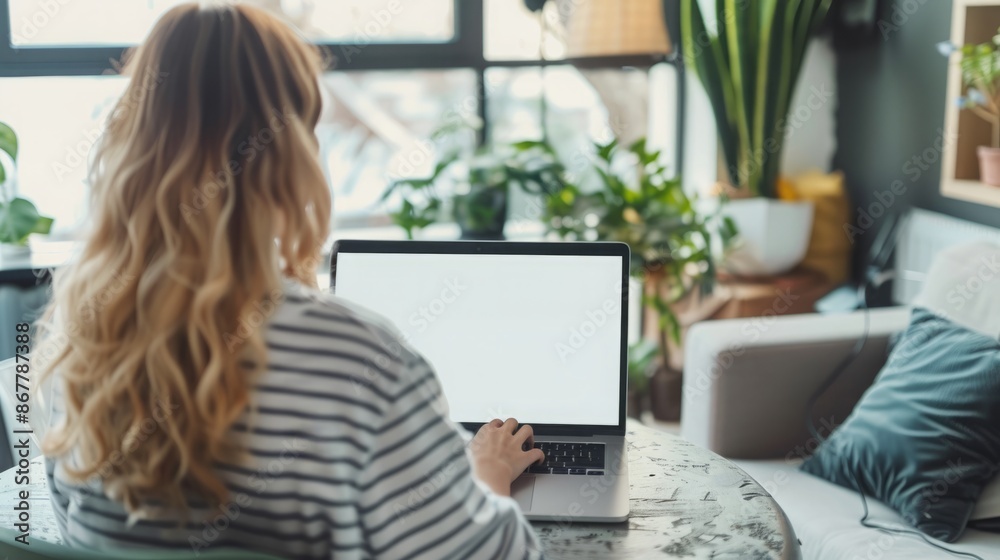 Domestic Digital Workspace: Women Working at Home with a Laptop and a Blank White Desktop Screen Domestic Digital Workspace: Women Working at Home with a Laptop and a Blank White Desktop Screen