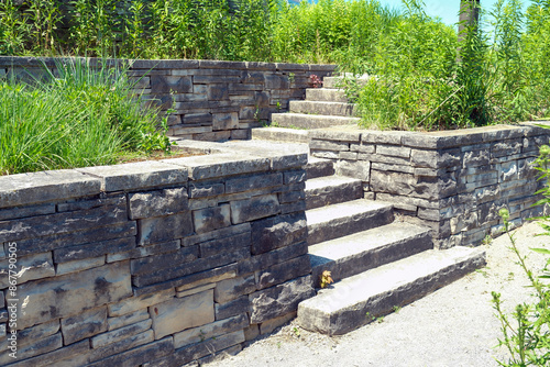 Luxury landscaping with natural stone retaining wall and coping, wide steps and landing.