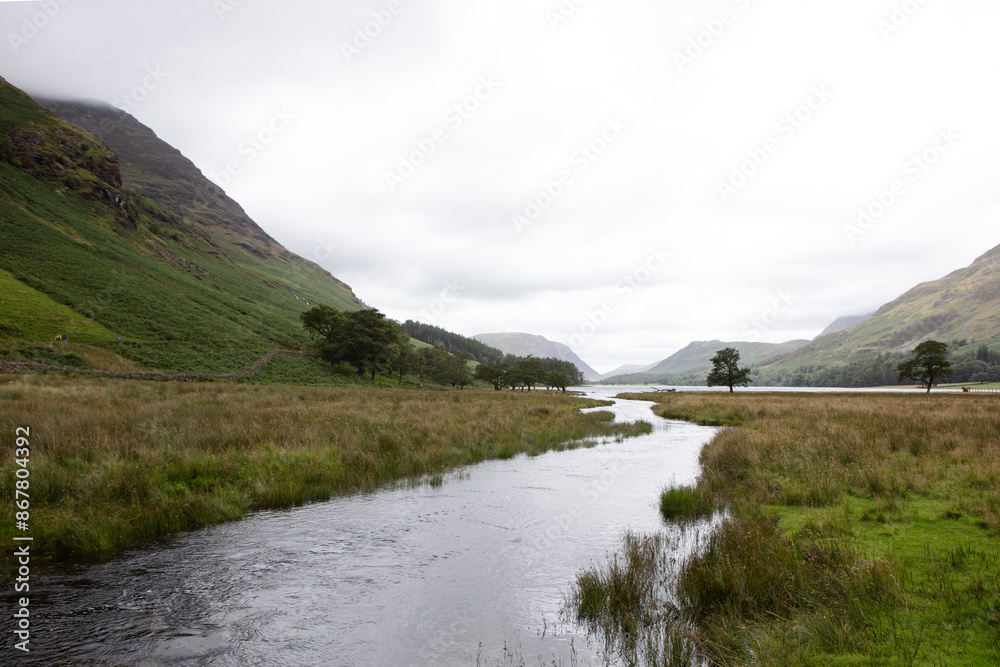 A stream flows into Lake Buttermere in the Lake District. A stream flows into Lake Buttermere in the Lake District.
