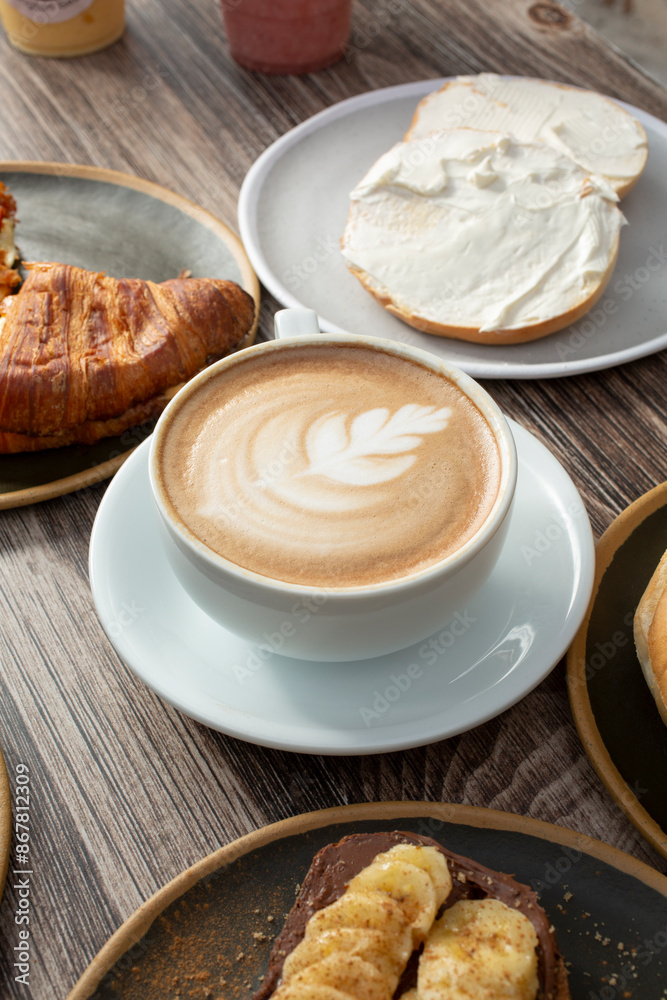 A view of a coffee latte cup among other breakfast entrees.