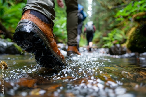 Outdoor adventure: hikers' boots walking through a forest stream