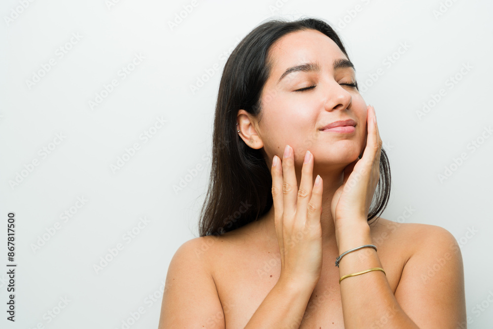 Serene hispanic woman enjoys a relaxing skincare session in a well-lit studio, exuding natural beauty and self-care contentment Serene hispanic woman enjoys a relaxing skincare session in a well-lit studio, exuding natural beauty and self-care contentment