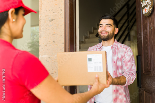 фотографія Handsome young man happily receiving a package from a female delivery person at