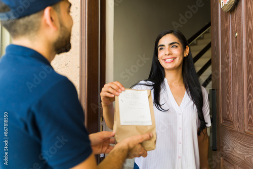 Photography Happy Latin young woman receiving a delivery of medication from a courier at her