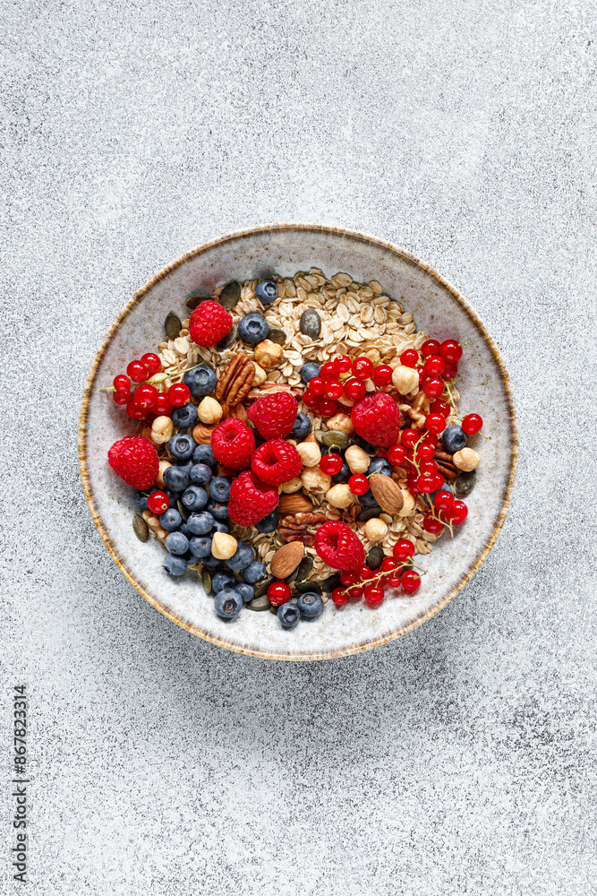 Muesli with organic berries and nuts. Oat muesli with raspberry, blueberry, red currant, almond, pecan, walnut, cashew, hazelnut and pumpkin seeds. Healthy food, top view
