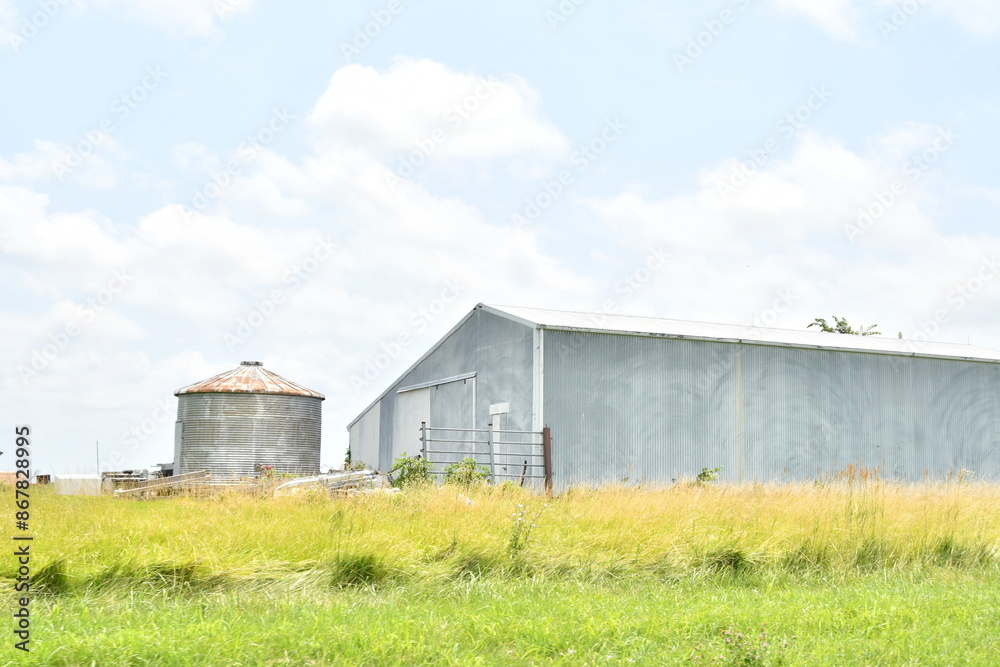 Metal Barn and Grain Bin in a Farm Field Metal Barn and Grain Bin in a Farm Field