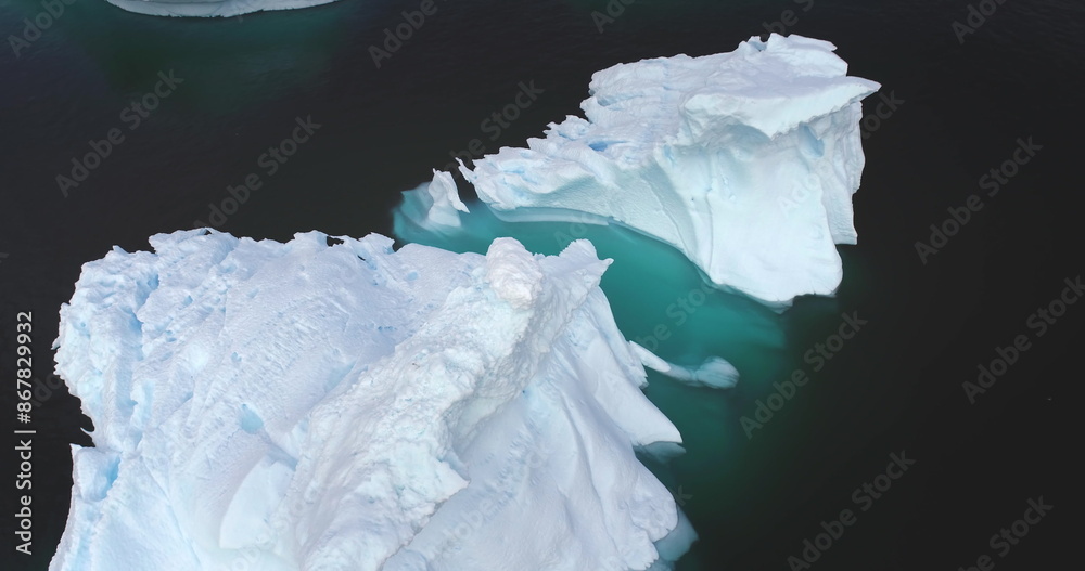 Obraz premium Melting icebergs drifting arctic ocean aerial view close up drone panorama. Environment ecological issue of global warming. Climate change at polar glaciers landscape. Antarctica wild nature landscape