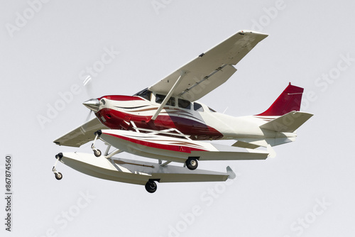 Seaplane flyby isolated on white background. A pass to adventure, a small, single engine propeller plane on amphibious floats. Airborne aircraft with high wings photo