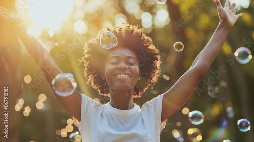 Elderly african american woman happily playing with colorful bubbles outdoors in sunny setting photo