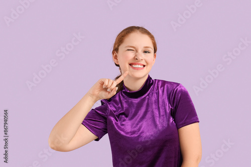 Young redhead woman pointin...