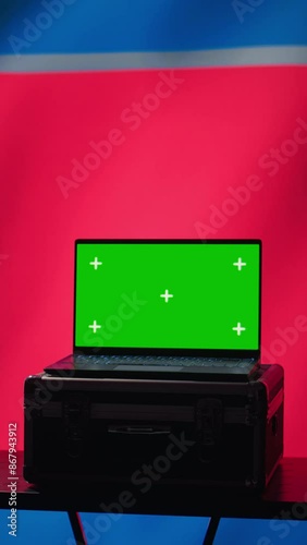 Vertical video North Korea secret police agent uses mass propaganda tools on green screen laptop to influence population minds. Pyongyang regime commits PsyOp sabotage using mockup device, camera B photo