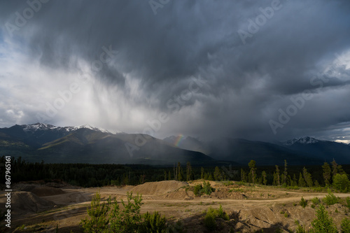 Beautiful summer storm over the rocky mountains with Rainbow