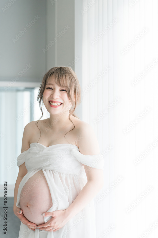 家のカーテンの前でマタニティフォトの撮影をする妊婦のアジア人女性
家のカーテンの前でマタニティフォトの撮影をする妊婦のアジア人女性
