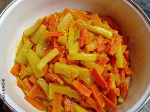 Acar bumbu kuning or yellow spice pickles. Cucumbers and carrots are cut into small lengths and then cooked with spices such as shallots, garlic, pepper, turmeric, ginger, candlenuts and vinegar.
 photo