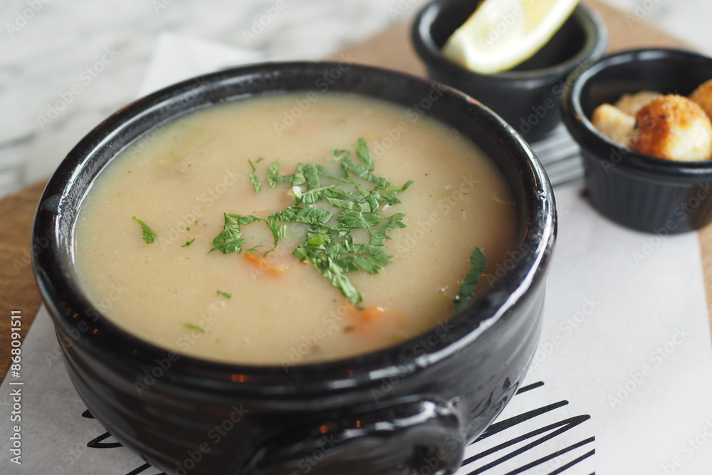 Enjoy a Delicious Bowl of Soup topped with Fresh Parsley in a Stylish Black Ceramic Bowl Enjoy a Delicious Bowl of Soup topped with Fresh Parsley in a Stylish Black Ceramic Bowl