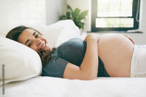 Portrait, happy and pregnant woman in home to relax, maternity or expecting baby in house. Pregnancy, future and smile of mother touching healthy abdomen, belly and stomach for prenatal care in bed
