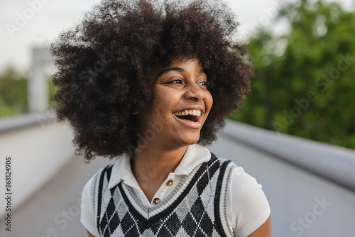 Joyful Young Woman with Afro Hairstyle Laughing Outdoors