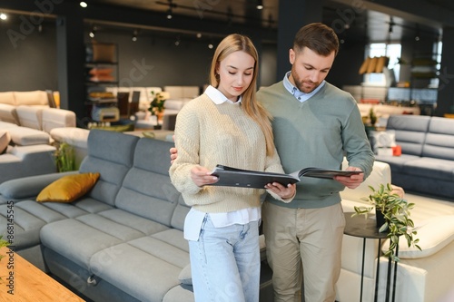 Couple choosing sofa and pillows at furniture store photo