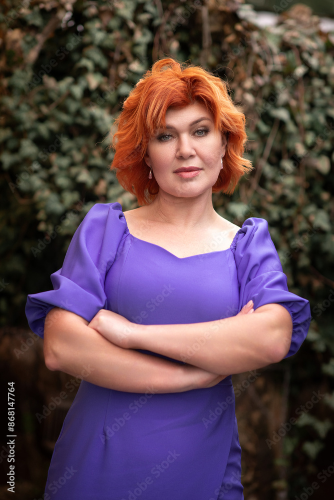 Portrait of a beautiful red-haired woman in a purple dress. Portrait of a beautiful red-haired woman in a purple dress.