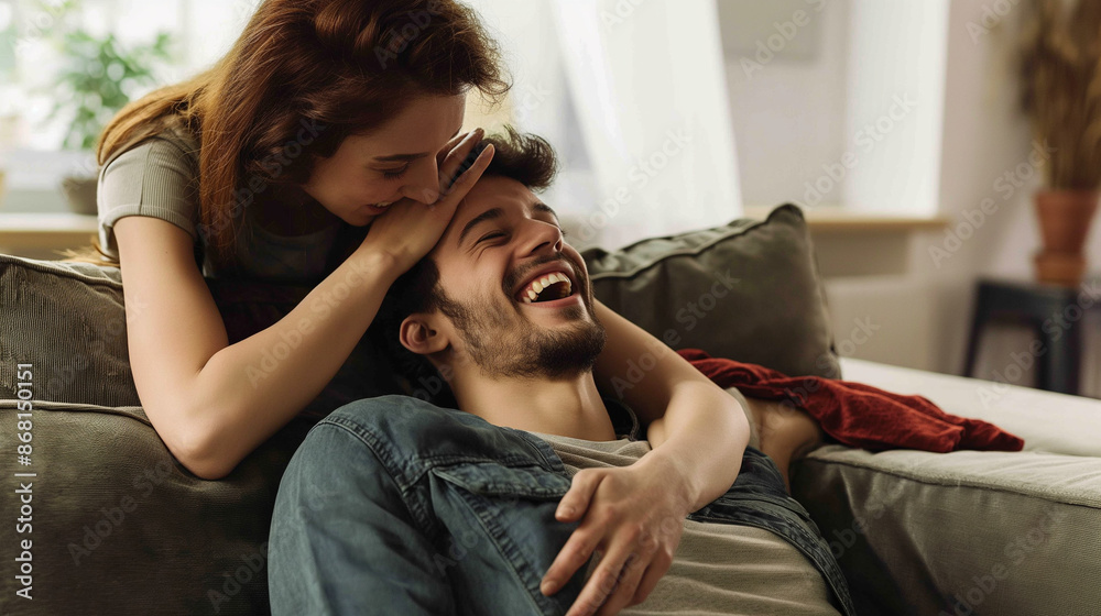 A happy couple laughing together in a cozy indoor setting. A happy couple laughing together in a cozy indoor setting.