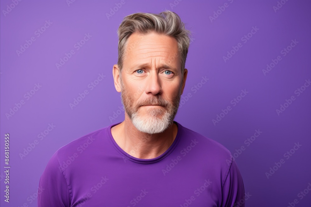 Portrait of a handsome mature man with grey hair and beard on a purple background. Portrait of a handsome mature man with grey hair and beard on a purple background.