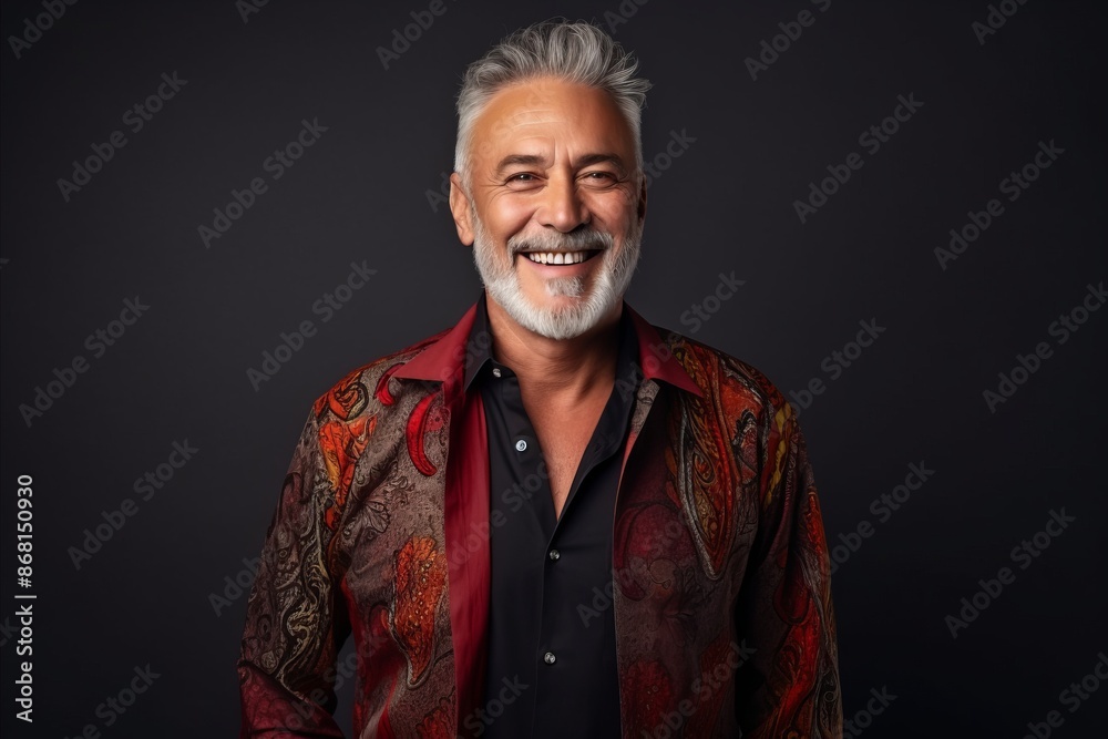 Portrait of a happy senior man in a colorful shirt on a dark background. Portrait of a happy senior man in a colorful shirt on a dark background.