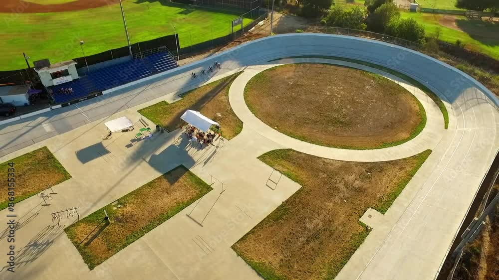 Aerial: Drone Tilt Up Shot Of Male Friends Practicing Riding Bicycles In Encino Velodrome On Sunny Day - Los Angeles, California Aerial: Drone Tilt Up Shot Of Male Friends Practicing Riding Bicycles In Encino Velodrome On Sunny Day - Los Angeles, California