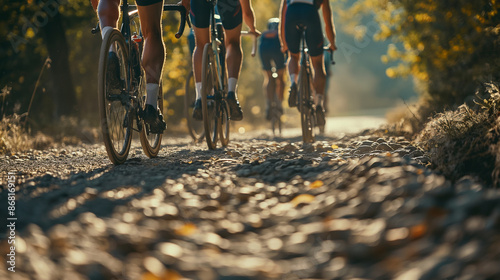 Group of athletes cycling on rough dirt path. Low angle view.