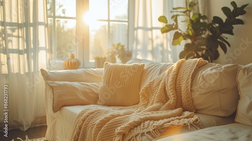 Fototapeta Naklejka Na Ścianę i Meble -  Background: A minimal and contemporary home setup with a blank wall, light floor, and white furniture, complemented by a luxurious lounge area with a cozy sofa and decorative plants for a serene livin