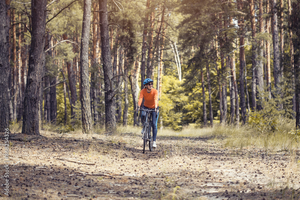 woman cyclist rides in the forest on a bike. woman cyclist rides in the forest on a bike.