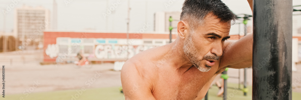 Middle aged muscular man resting after workout outdoors, panorama Middle aged muscular man resting after workout outdoors, panorama
