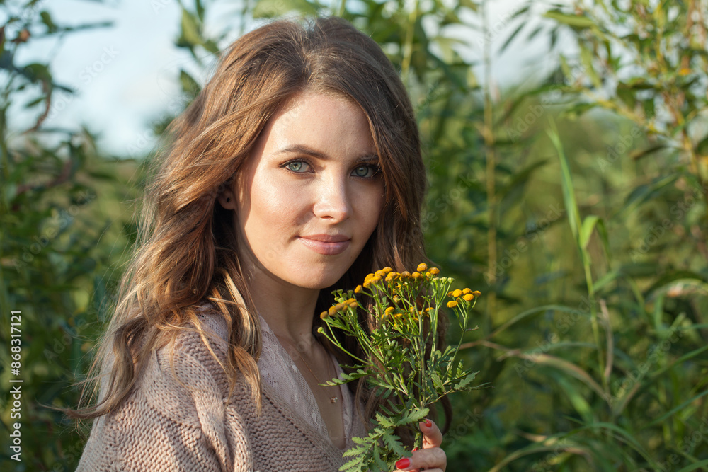 Beautiful healthy young model woman with clean fresh skin, natural make-up and curly hairstyle against green grass background, outdoor portrait Beautiful healthy young model woman with clean fresh skin, natural make-up and curly hairstyle against green grass background, outdoor portrait