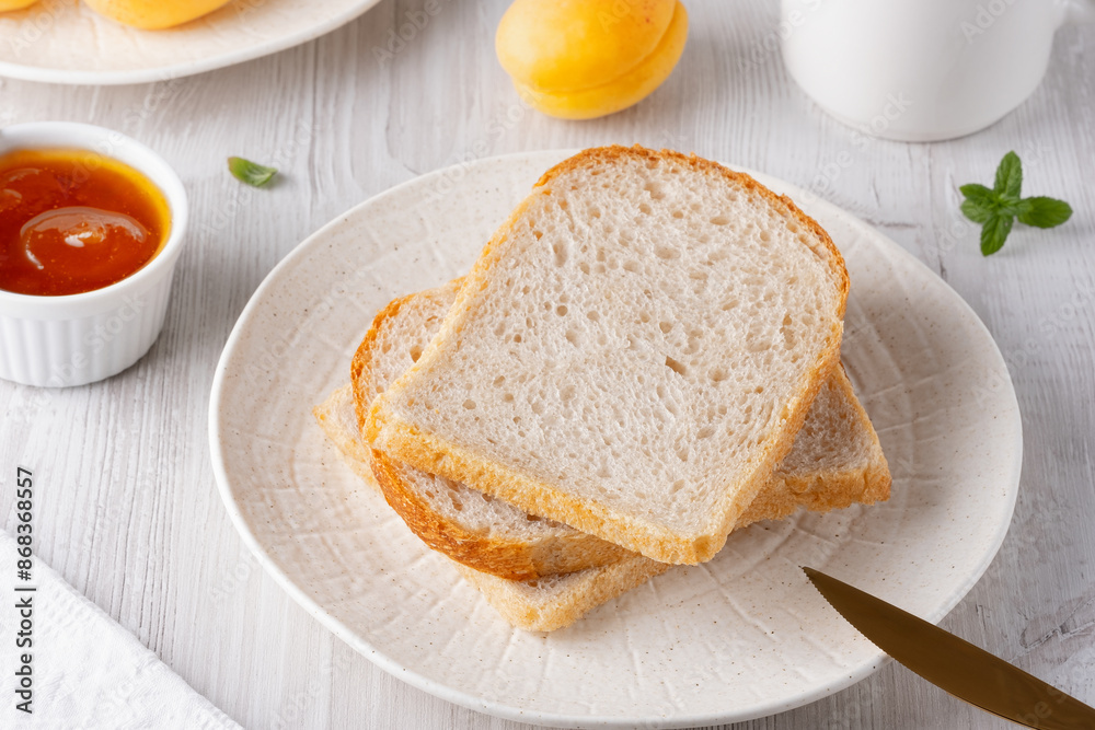 Slices of white bread and apricot jam for breakfas Slices of white bread and apricot jam for breakfas