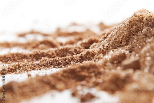 Close-up Texture of Brown Sugar Crystals on a White Background