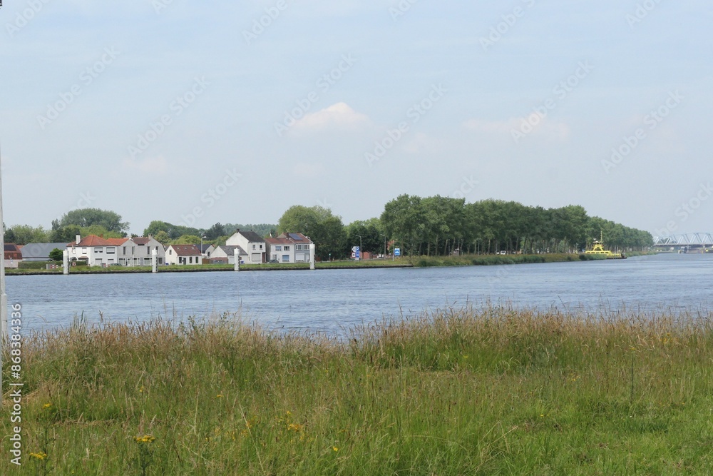 a row houses of the village Sluiskil at the quayside of the canal Ghent - Terneuzen in the dutch countryside in Zeeland