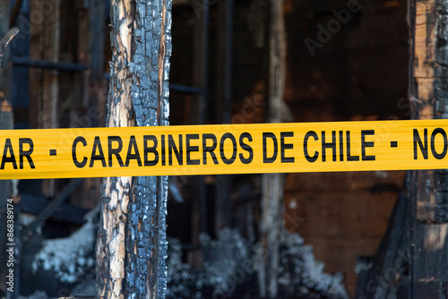 Chilean carabineer tape in front of a burnt house