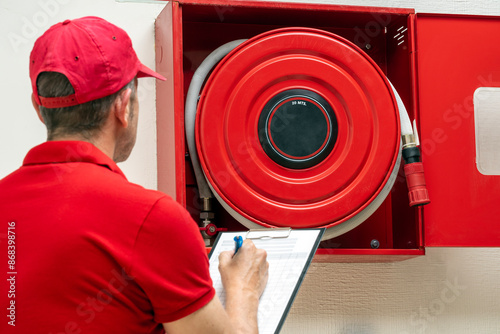 Cuadro en lienzo Technician performing inspection of fire hose cabinet