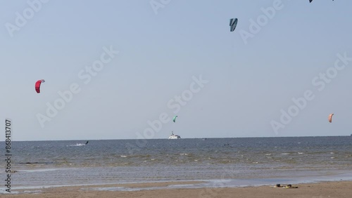 people kitesurfing, kiteboarding  on the sea, strong wind, waves