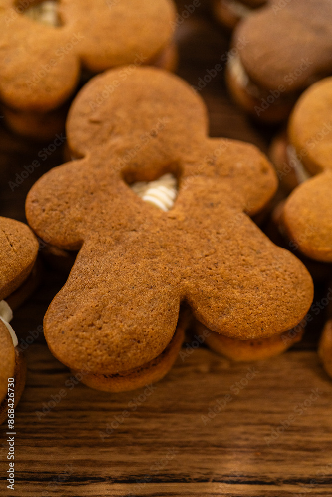 Fototapeta premium Making Festive Gingerbread Sandwiches on Rustic Wooden Table
