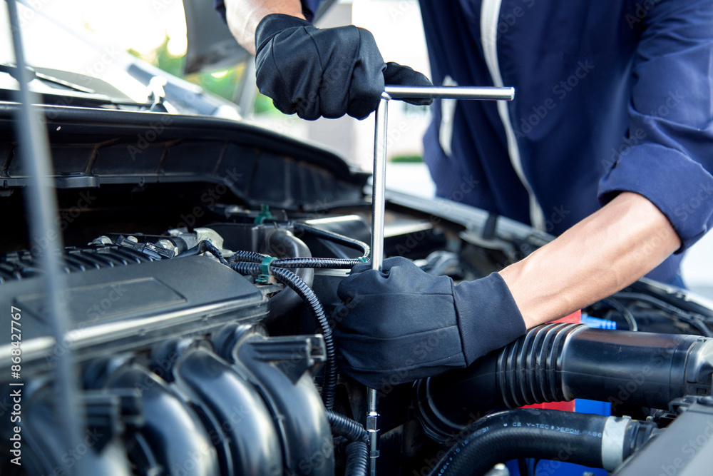 Professional mechanic working on the engine , repairing a car engine automotive workshop with a wrench, car service and maintenance,Repair service.