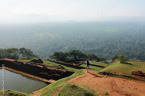 A tourist woman enjoying the view from the top of the Sigiriya Rock in Sri Lanka. A an ancient mountain fortress