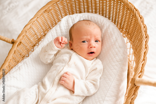 Photos Cute baby wake up in baby straw bassinet close up