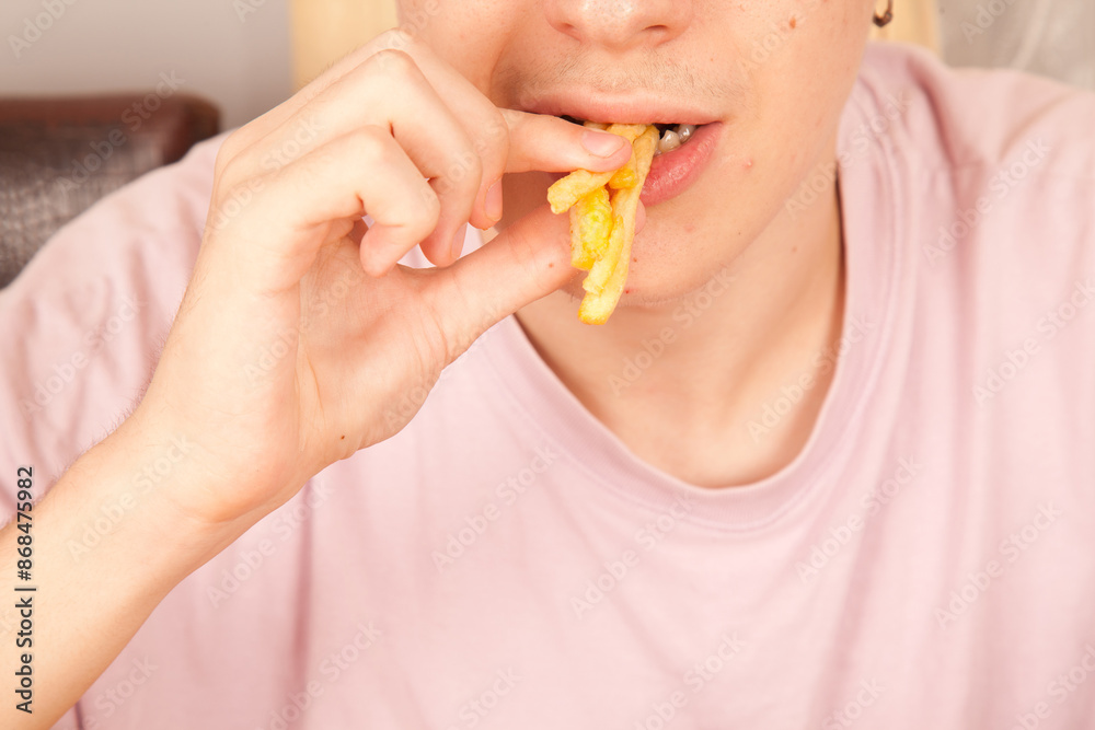 Caucasian man eating fried potatoes chips, American fast food culture, cooked potatoes pieces Caucasian man eating fried potatoes chips, American fast food culture, cooked potatoes pieces