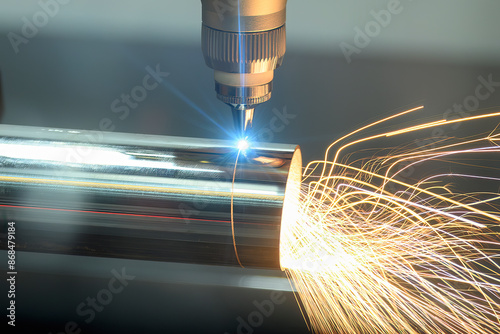 Close up scene the fiber laser cutting machine cut the stainless steel tube with sparkling light.