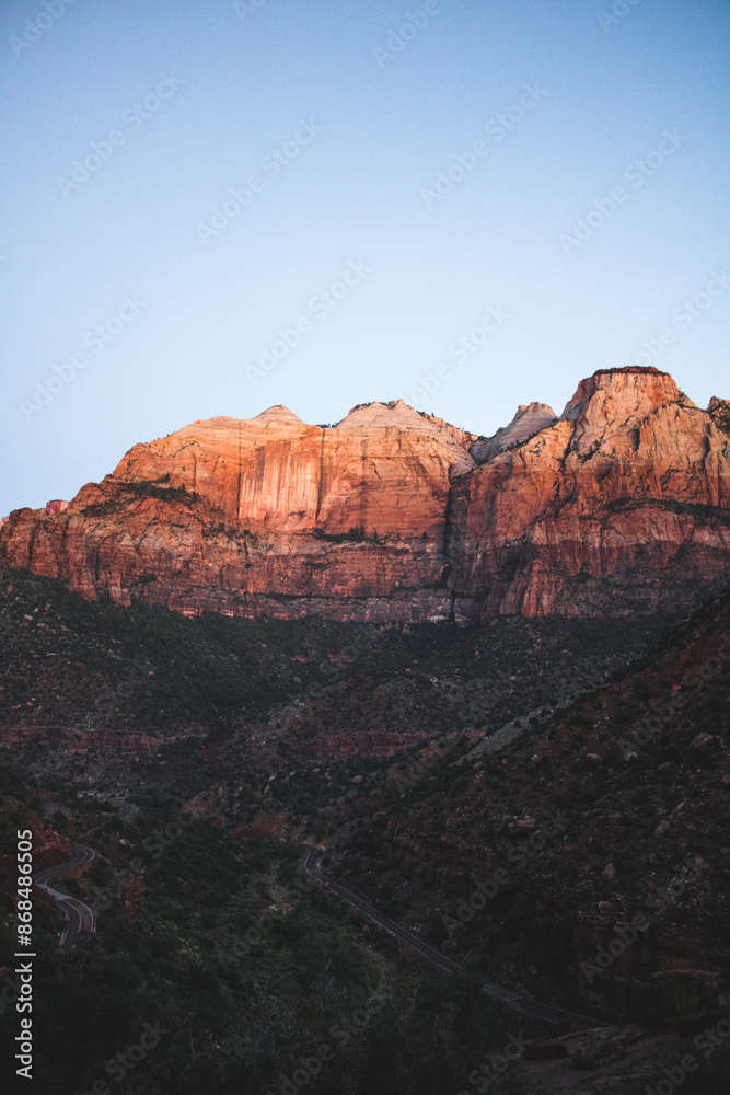 Naklejka premium Blick auf sonnenbeleuchtete Klippe im Zion-Nationalpark bei Dämmerung