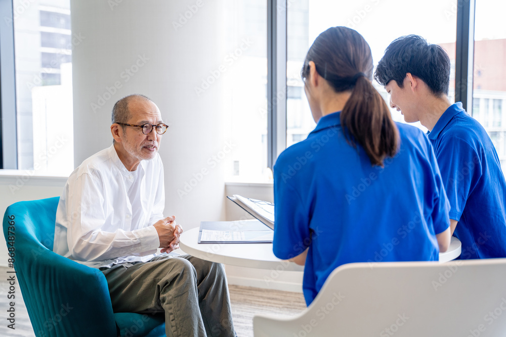 Obraz premium 談話する介護スタッフとシニア男性