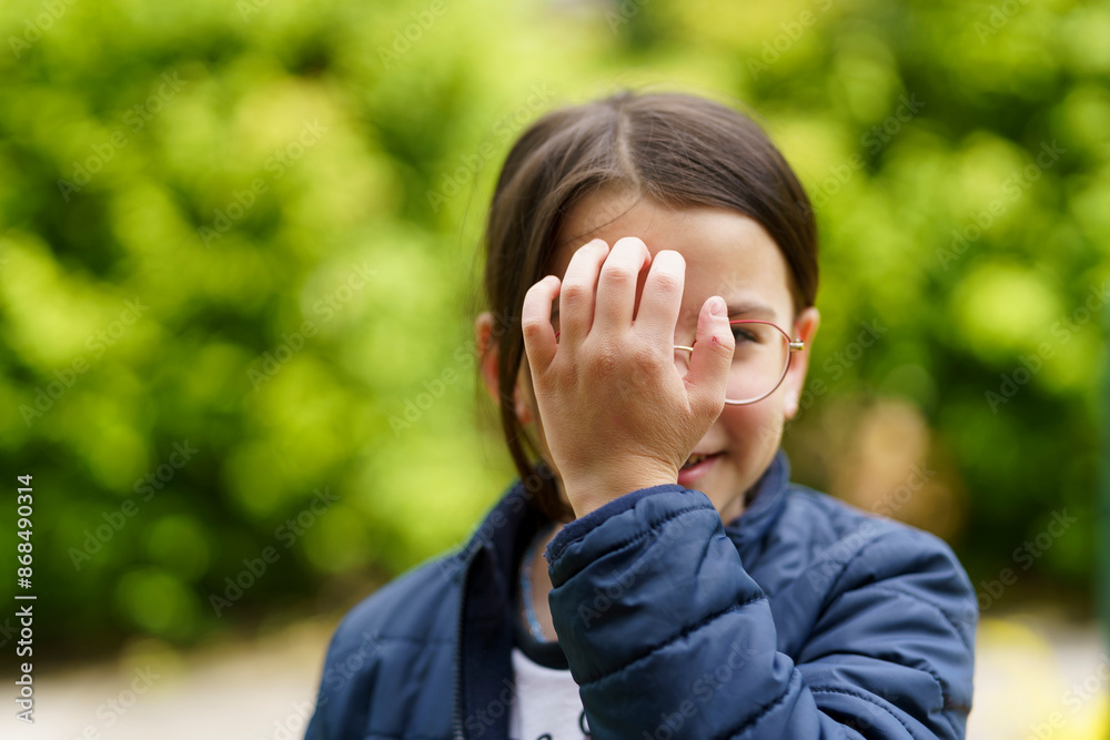 Little cheerful teenage girl wearing glasses outdoors. Happy childhood concept Little cheerful teenage girl wearing glasses outdoors. Happy childhood concept